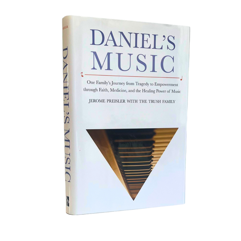 Image of the "Daniel's Music" biography, standing on it's side. The cover features an inverted triangle containing a photo of a piano keyboard
