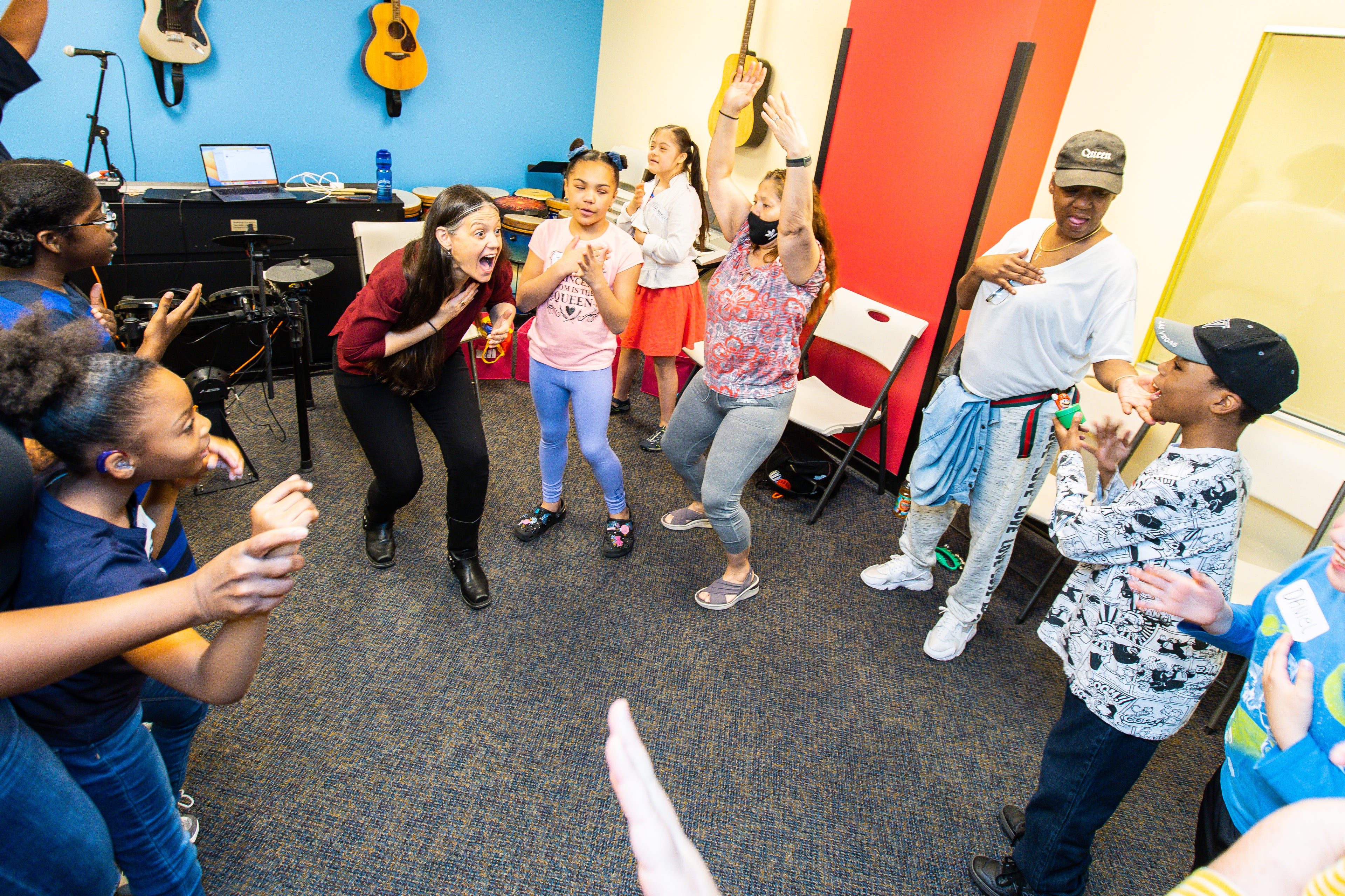 Image of a class at Daniel's Music Foundation. The participants are clapping and dancing.
